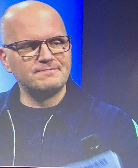 Jan Jacobs groot op het projectiescherm tijdens een gesprek op het podium
